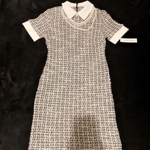 Knee length black and white dress with pearl necklace accessory